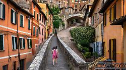 2. Ragazza corre su per la strada. Perugia, Umbria, Italia, 2022 &copy;Steve McCurry