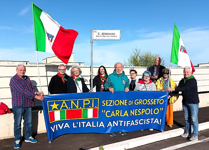 Il flash mob dell'Anpi con il cartello stradale: "Via Almirante, gerarca fascista e razzista"