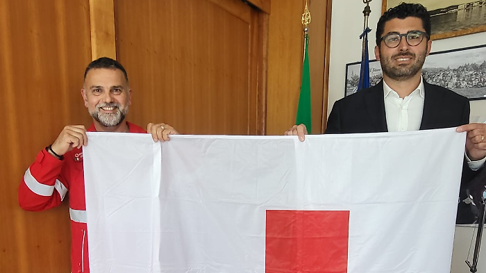 È la Settimana della Croce Rossa: bandiera esposta a palazzo comunale e in piazza.  E il municipio si colora di rosso. 